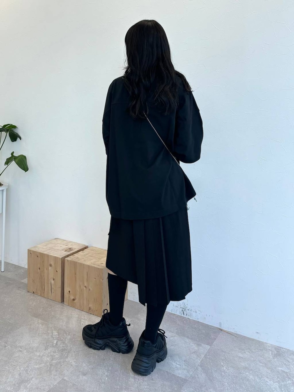 ブラック系のスニーカー、シルバー系のショルダーバッグ、ブラック系のスカートを着用したレディースの春コーディネートの6枚目の写真