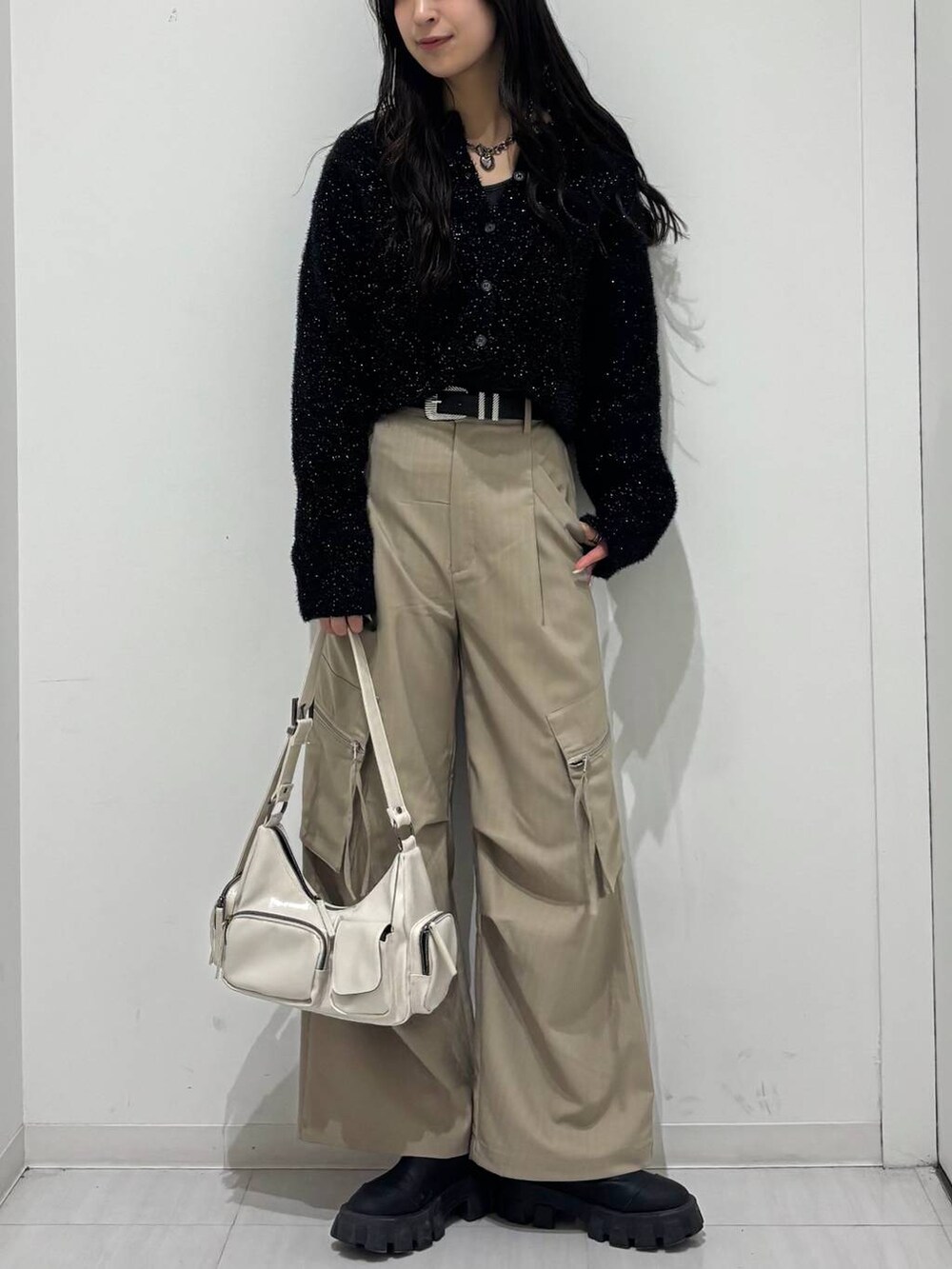 ホワイト系のショルダーバッグ、ベージュ系のカーゴパンツ、ブラック系のカーディガン/ボレロを着用したレディースの冬コーディネートの4枚目の写真