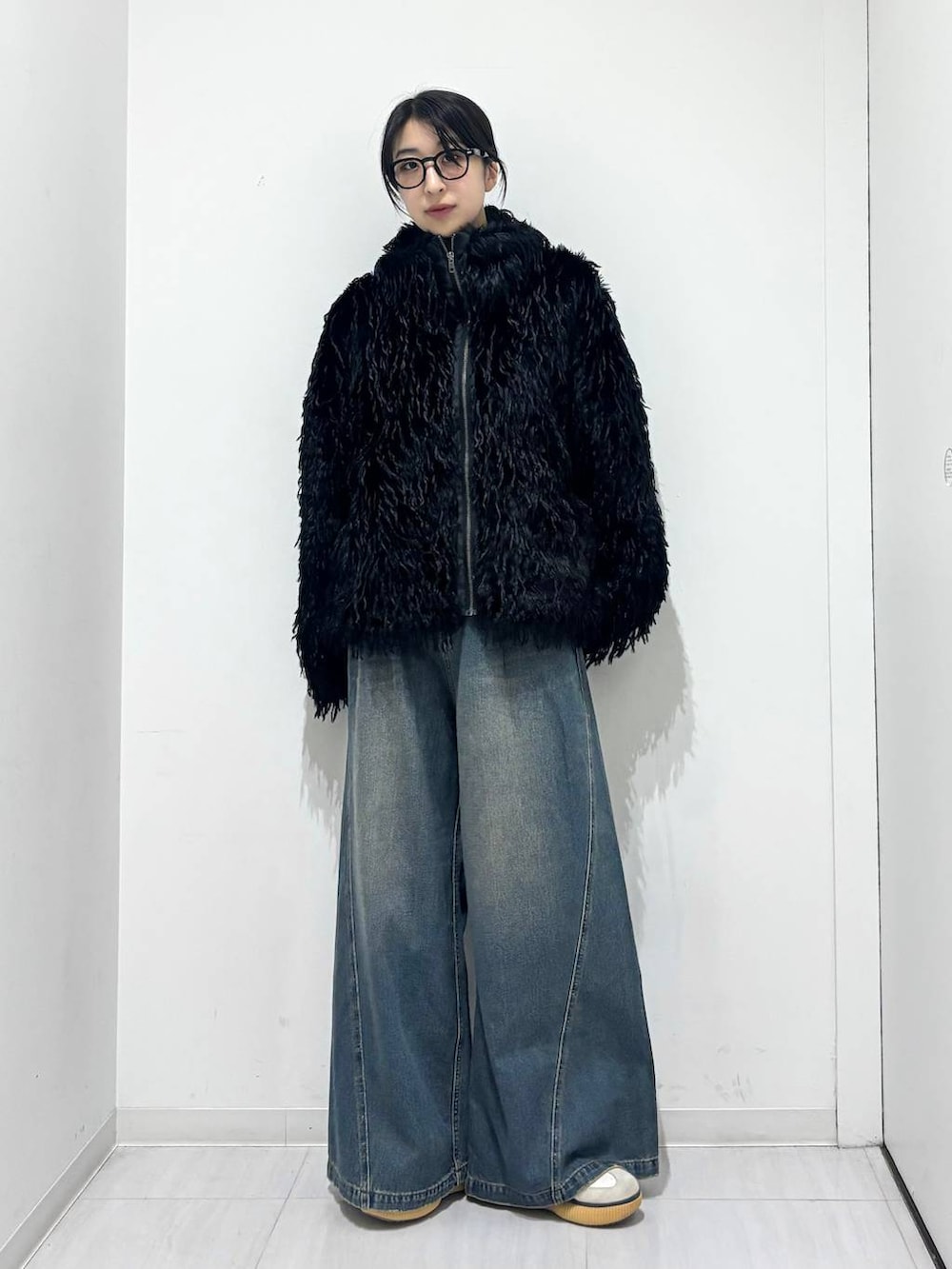 ブルー系のデニムパンツ、ブラック系のブルゾンを着用したレディースの秋コーディネートの5枚目の写真