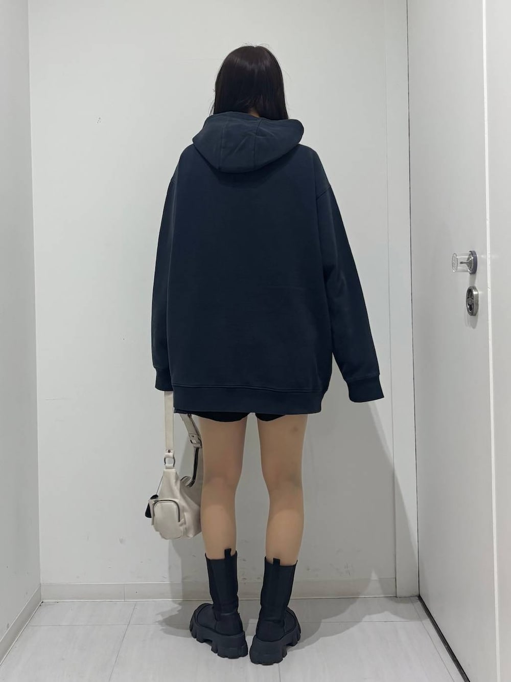 ホワイト系のショルダーバッグ、ブラック系のその他パンツ、ブルー系のパーカーを着用したレディースの冬コーディネートの3枚目の写真