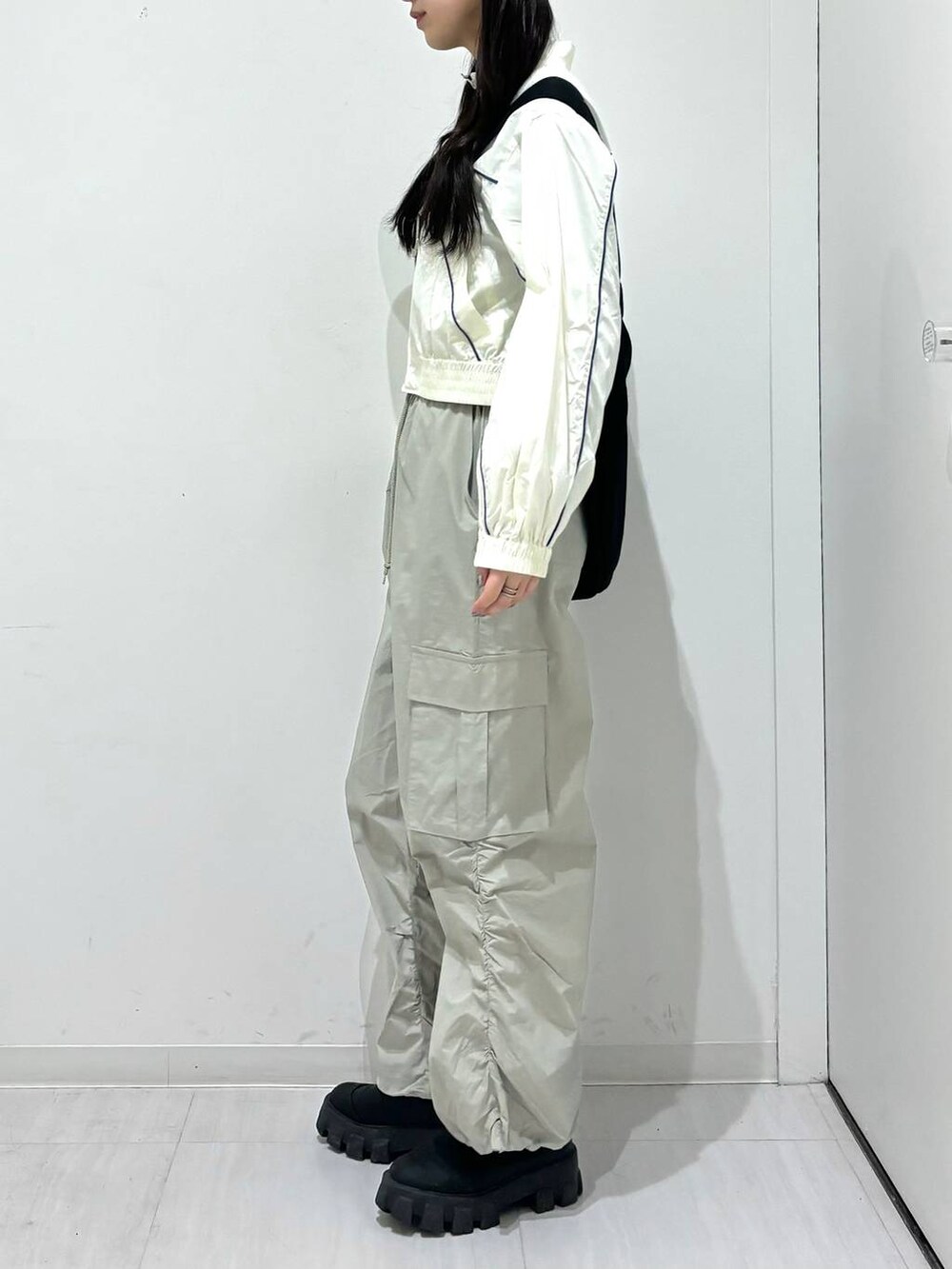 ホワイト系のブルゾン、グレー系のカーゴパンツ、ブラック系のショルダーバッグを着用したレディースの春コーディネートの2枚目の写真