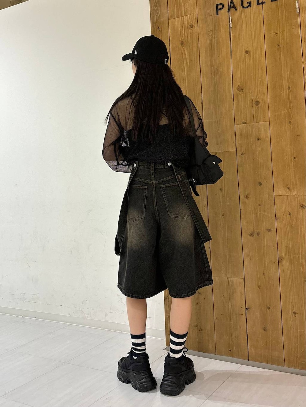 ブラック系のスニーカー、ブラック系のTシャツ/カットソー、ブラック系のデニムパンツを着用したレディースの春コーディネートの4枚目の写真