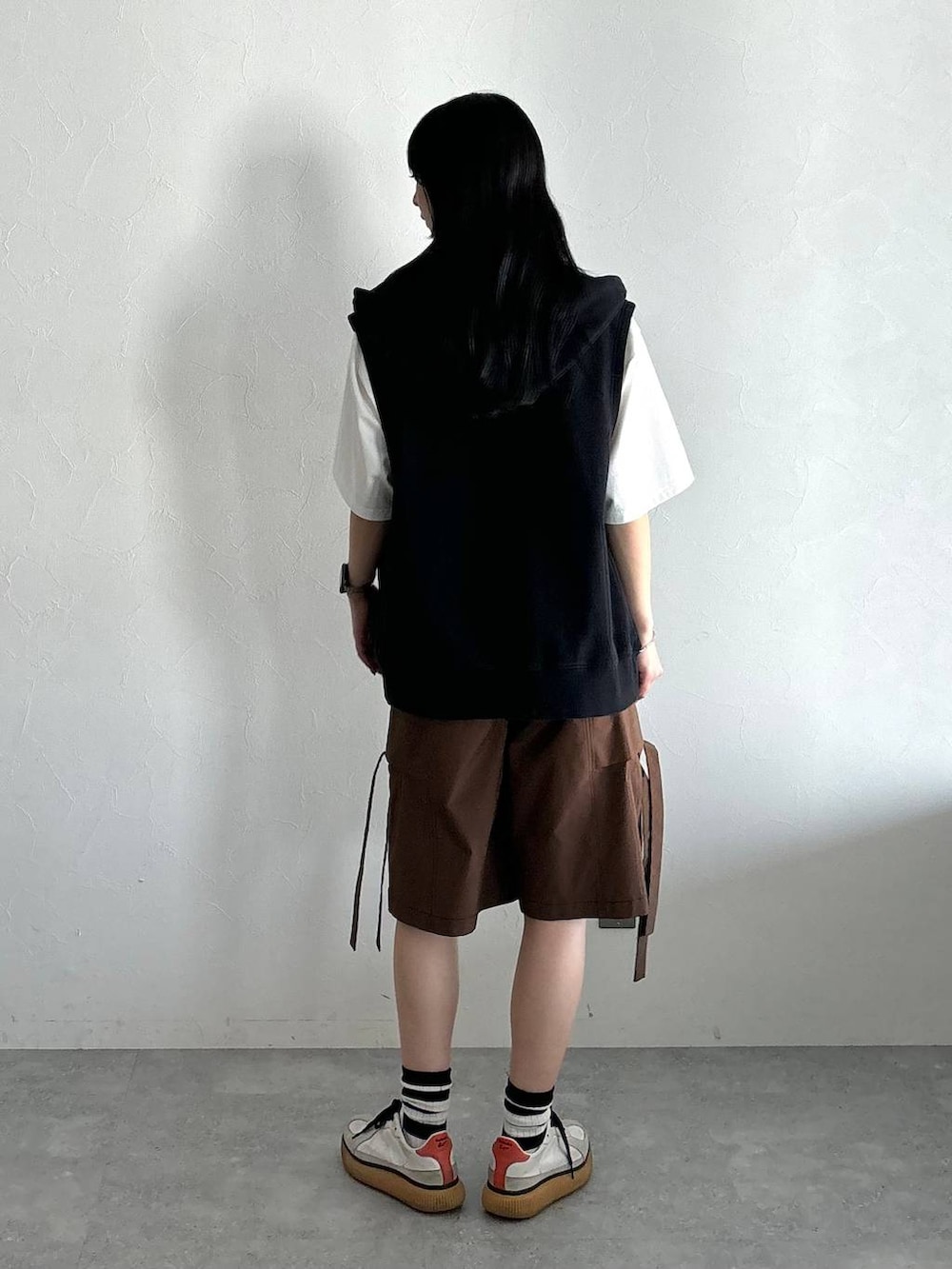 ブラック系のパーカー、ホワイト系のTシャツ/カットソー、ブラウン系のカーゴパンツを着用したレディースの夏コーディネートの4枚目の写真