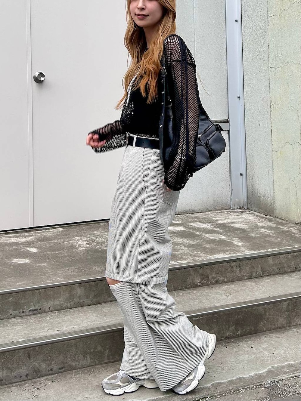 ブラック系のTシャツ/カットソー、ホワイト系のその他パンツ、ブラック系のショルダーバッグを着用したレディースの春コーディネートの4枚目の写真