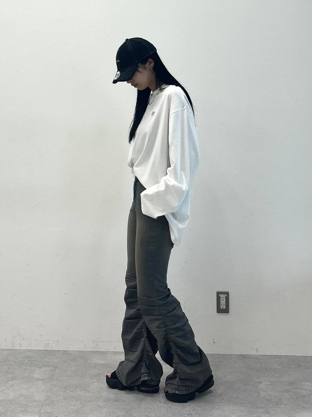 ブルー系のデニムパンツ、ホワイト系のTシャツ/カットソー、ブラック系のキャップを着用したレディースの秋コーディネートの2枚目の写真