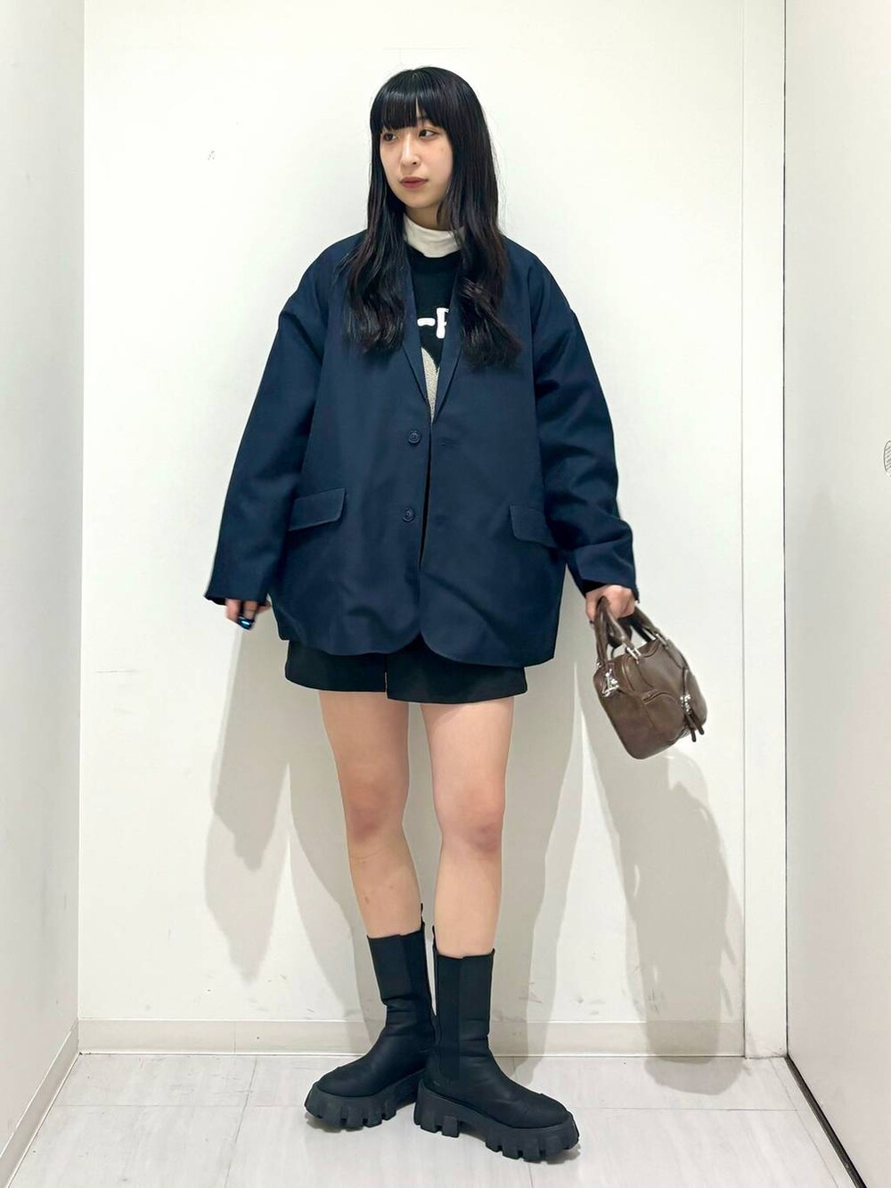 ブルー系のテーラードジャケット、ブラック系のスウェット、ブラック系のブーツを着用したレディースの冬コーディネートの2枚目の写真