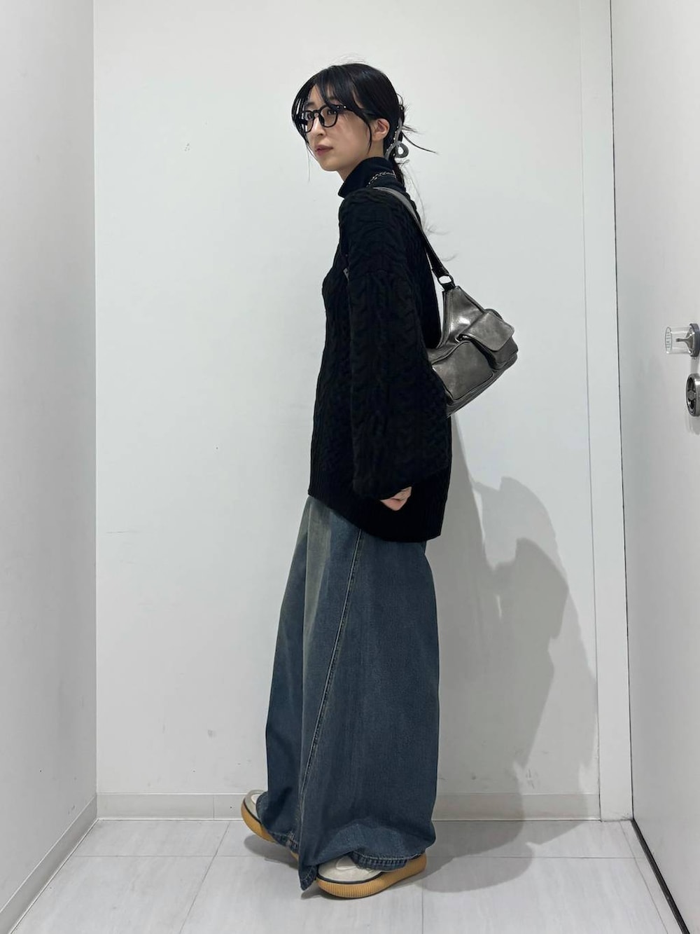 ブルー系のデニムパンツ、その他のショルダーバッグ、ブラック系のTシャツ/カットソーを着用したレディースの秋コーディネートの4枚目の写真