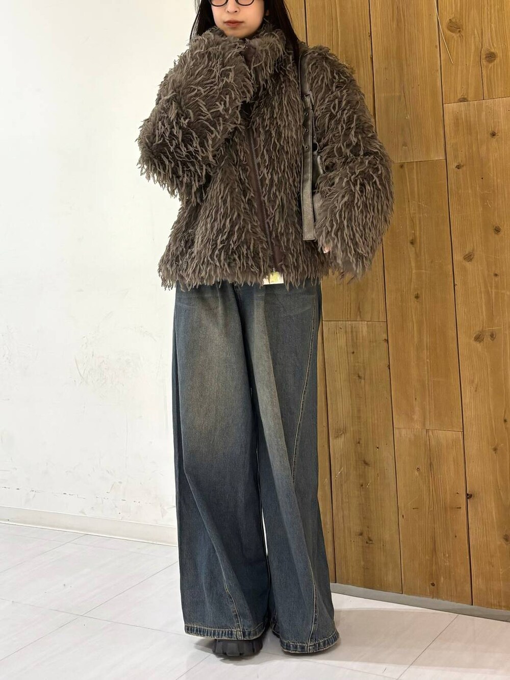 ブルー系のデニムパンツ、その他のショルダーバッグ、ブラウン系のブルゾンを着用したレディースの冬コーディネートの2枚目の写真