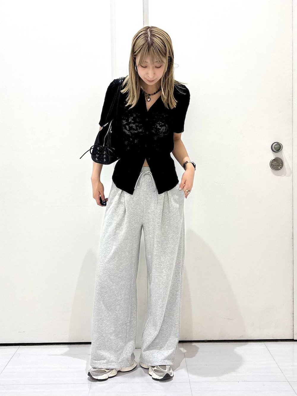 ブラック系のショルダーバッグ、ブラック系のシャツ/ブラウス、グレー系のスウェットパンツを着用したレディースの春コーディネートの2枚目の写真