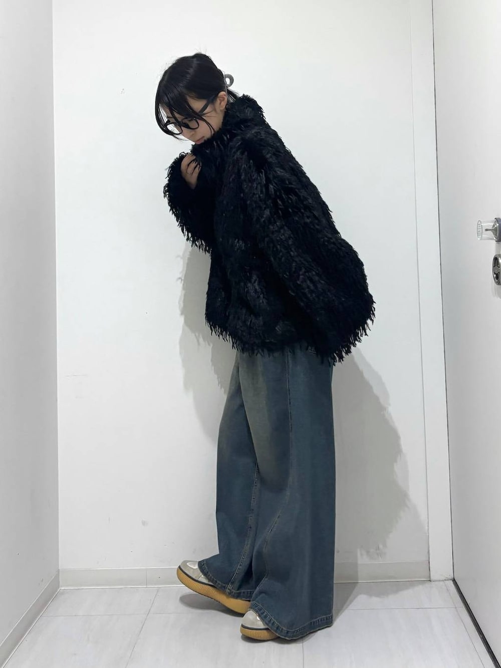 ブルー系のデニムパンツ、ブラック系のブルゾンを着用したレディースの秋コーディネートの3枚目の写真