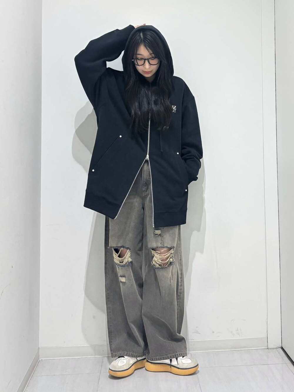 ブラック系のデニムパンツ、ブラック系のパーカーを着用したレディースの秋コーディネートの2枚目の写真