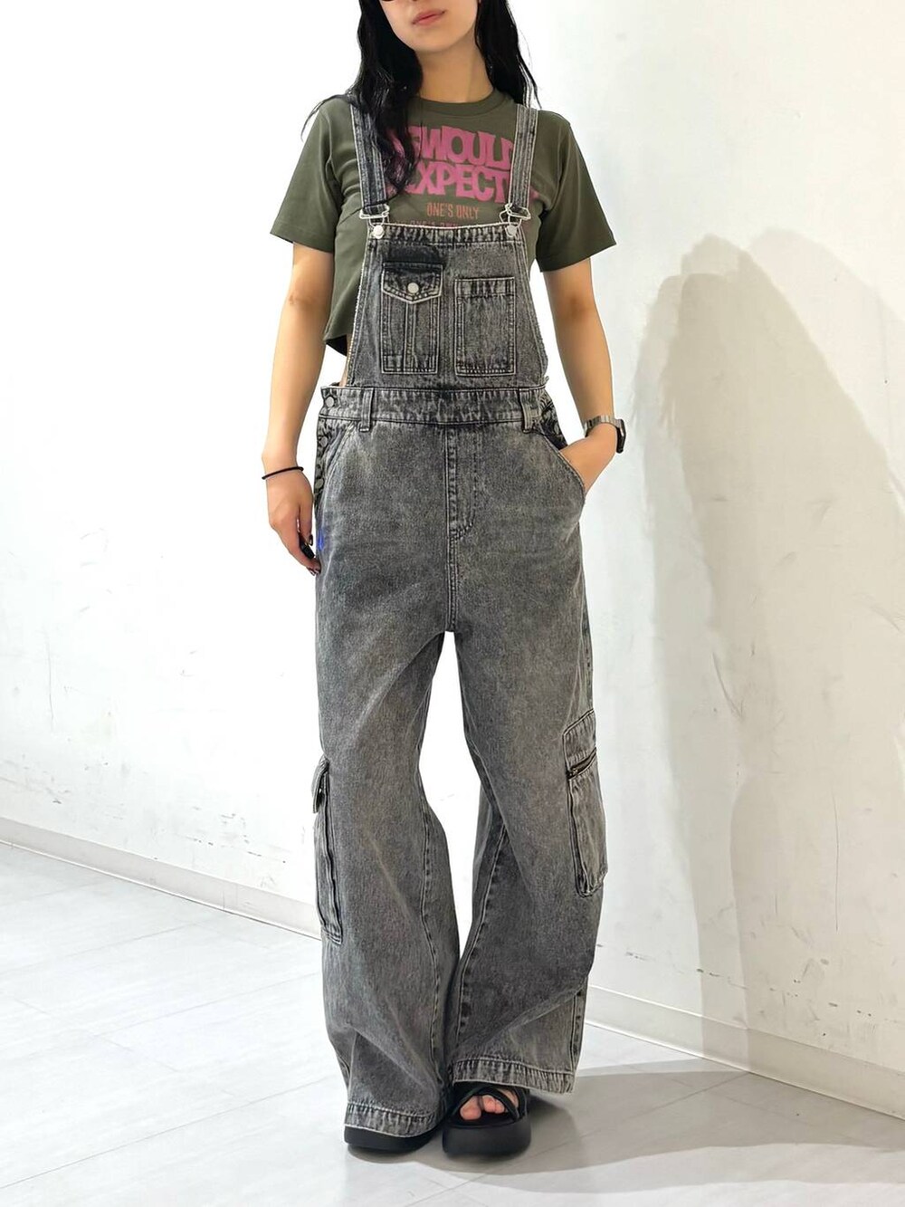 ブラック系のサンダル、ブラック系のサロペット/オーバーオール、グリーン系のTシャツ/カットソーを着用したレディースの夏コーディネートの2枚目の写真