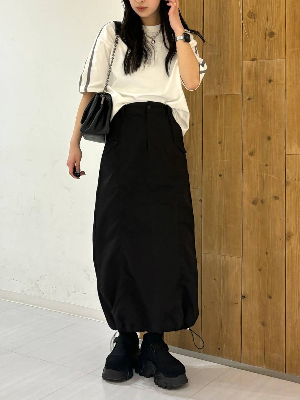 ブラック系のショルダーバッグ、ホワイト系のTシャツ/カットソー、ブラック系のスニーカーを着用したレディースの春コーディネートの5枚目の写真