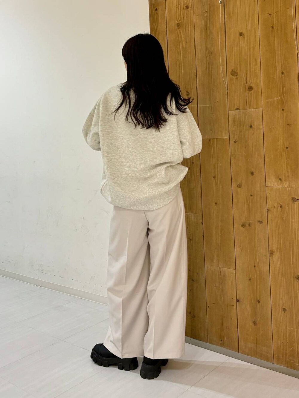 ブラック系のブーツ、ベージュ系のスラックス、ベージュ系のスウェットを着用したレディースの冬コーディネートの5枚目の写真