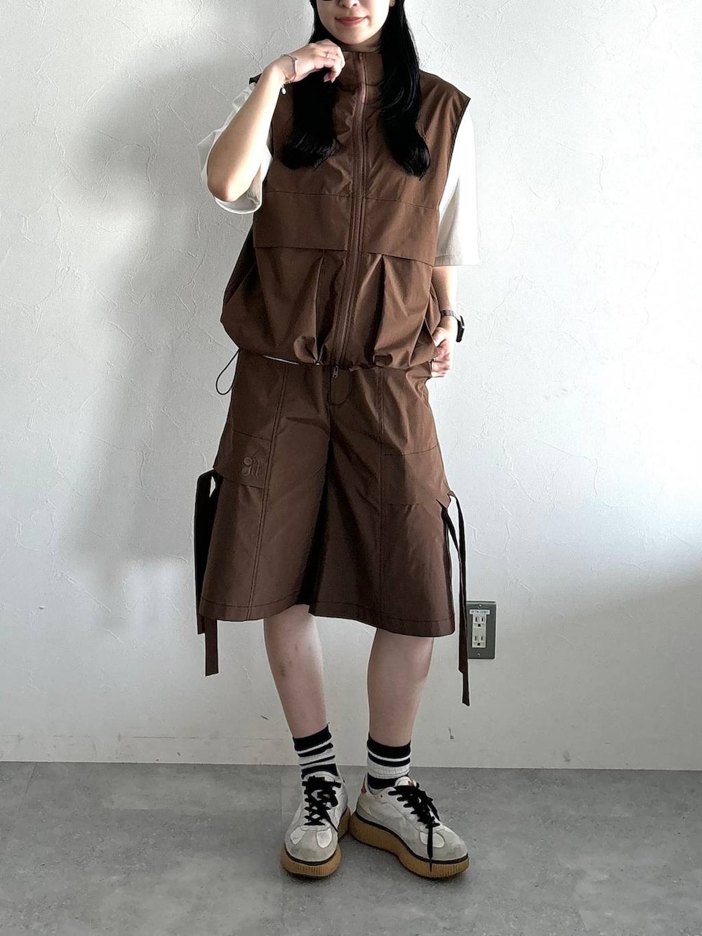 ホワイト系のTシャツ/カットソー、ブラウン系のベスト、ブラウン系のカーゴパンツを着用したレディースの夏コーディネートの2枚目の写真
