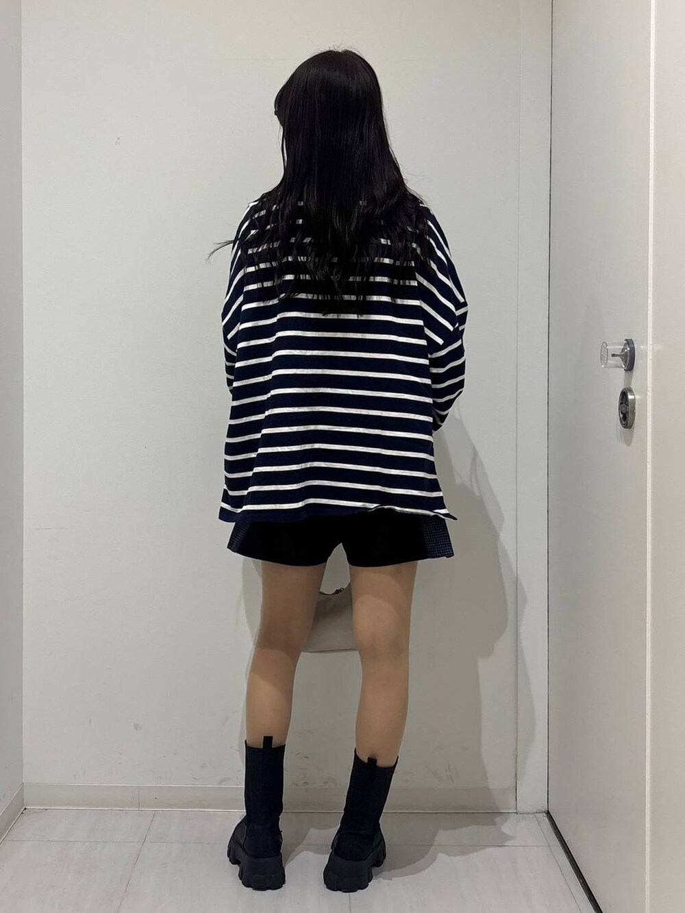 ホワイト系のショルダーバッグ、ブルー系のTシャツ/カットソー、ブラック系のその他パンツを着用したレディースの冬コーディネートの4枚目の写真