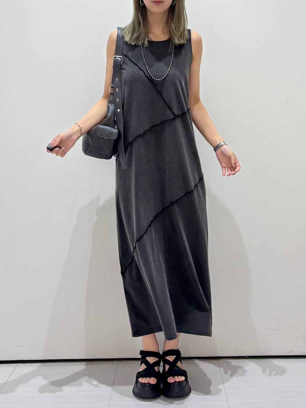 ブラック系のサンダル、ブラック系のワンピース、ブラック系のショルダーバッグを着用したレディースの春コーディネートの7枚目の写真