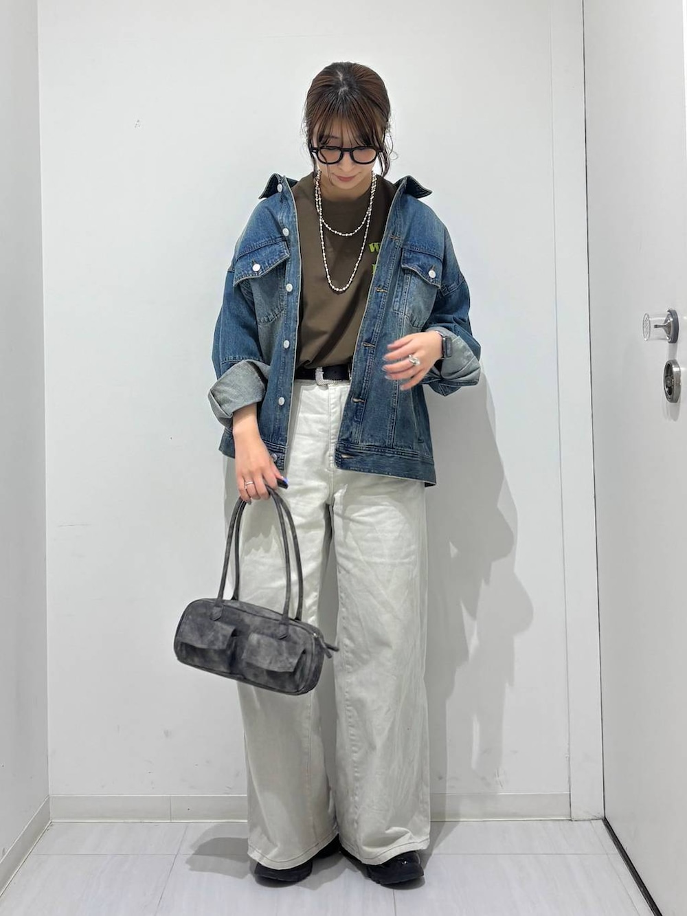 グレー系のデニムパンツ、ブラック系のスニーカー、ブルー系のデニムジャケットを着用したレディースの春コーディネートの2枚目の写真