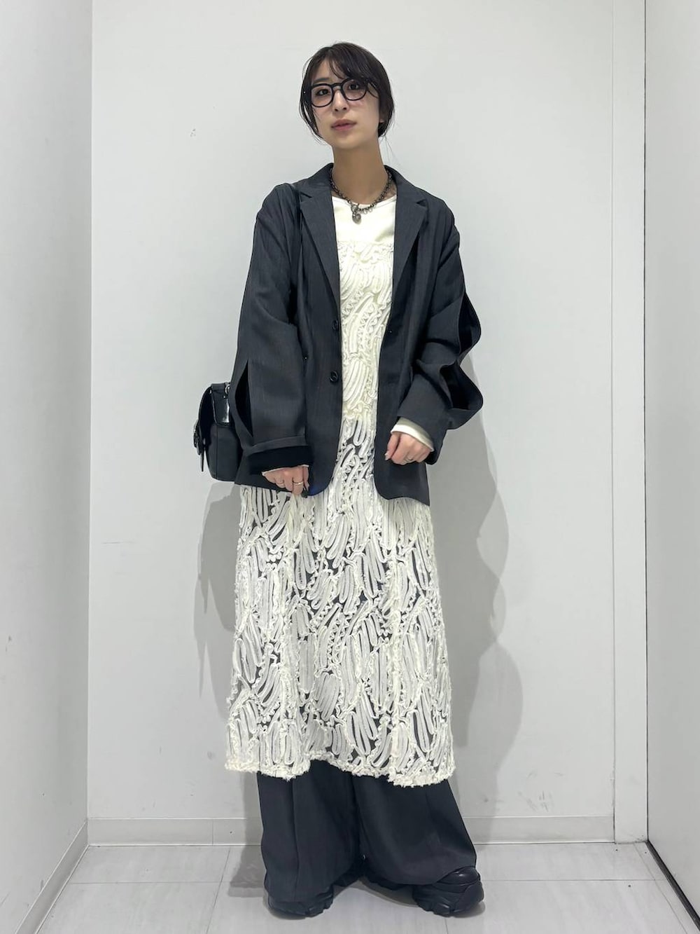 ブラック系のスニーカー、ホワイト系のワンピース、ブラック系のショルダーバッグを着用したレディースの冬コーディネートの6枚目の写真