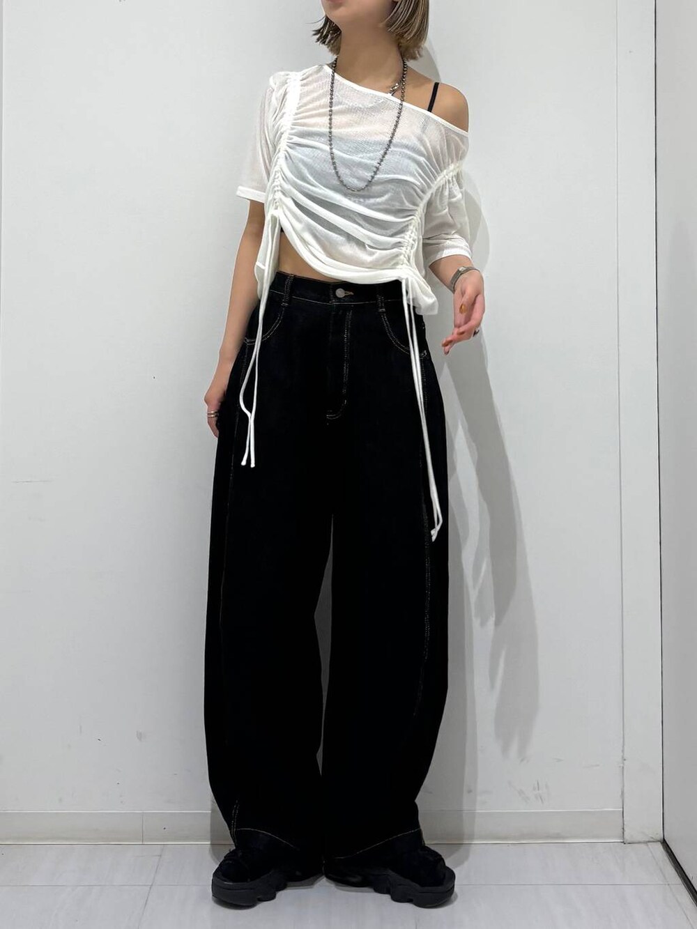 ブラック系のデニムパンツ、ホワイト系のTシャツ/カットソー、ブラック系のネックレスを着用したレディースの夏コーディネートの6枚目の写真