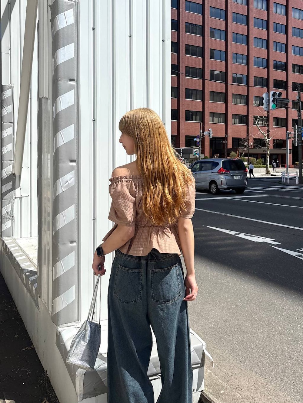 ブルー系のデニムパンツ、ブラウン系のシャツ/ブラウスを着用したレディースの春コーディネートの3枚目の写真