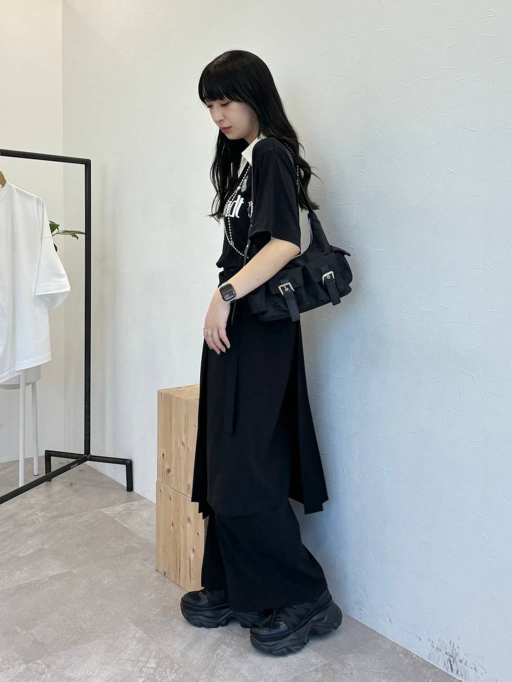 ブラック系のショルダーバッグ、ブラック系のスニーカー、ブラック系のスラックスを着用したレディースの春コーディネートの3枚目の写真