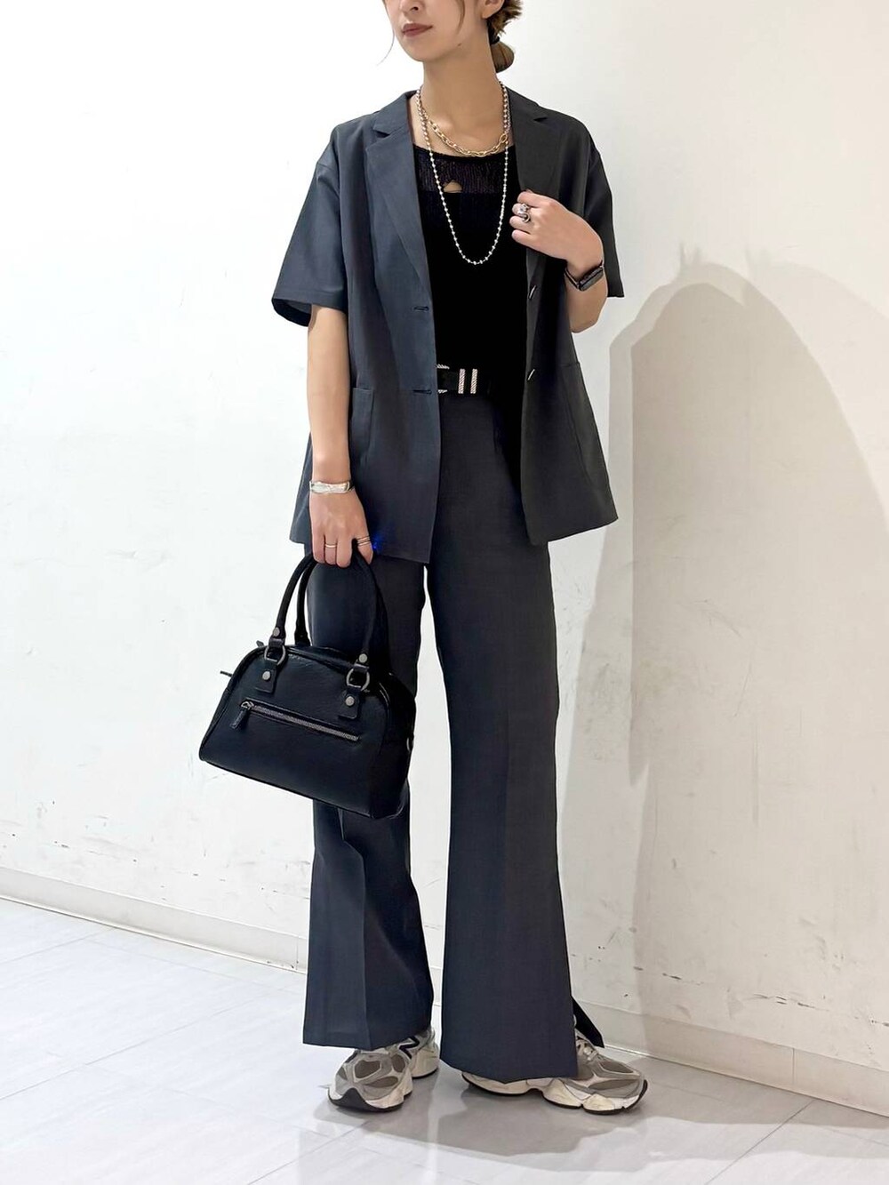 ブラック系のキャミソール、ブラック系のショルダーバッグ、ブラック系のベストを着用したレディースの夏コーディネートの3枚目の写真