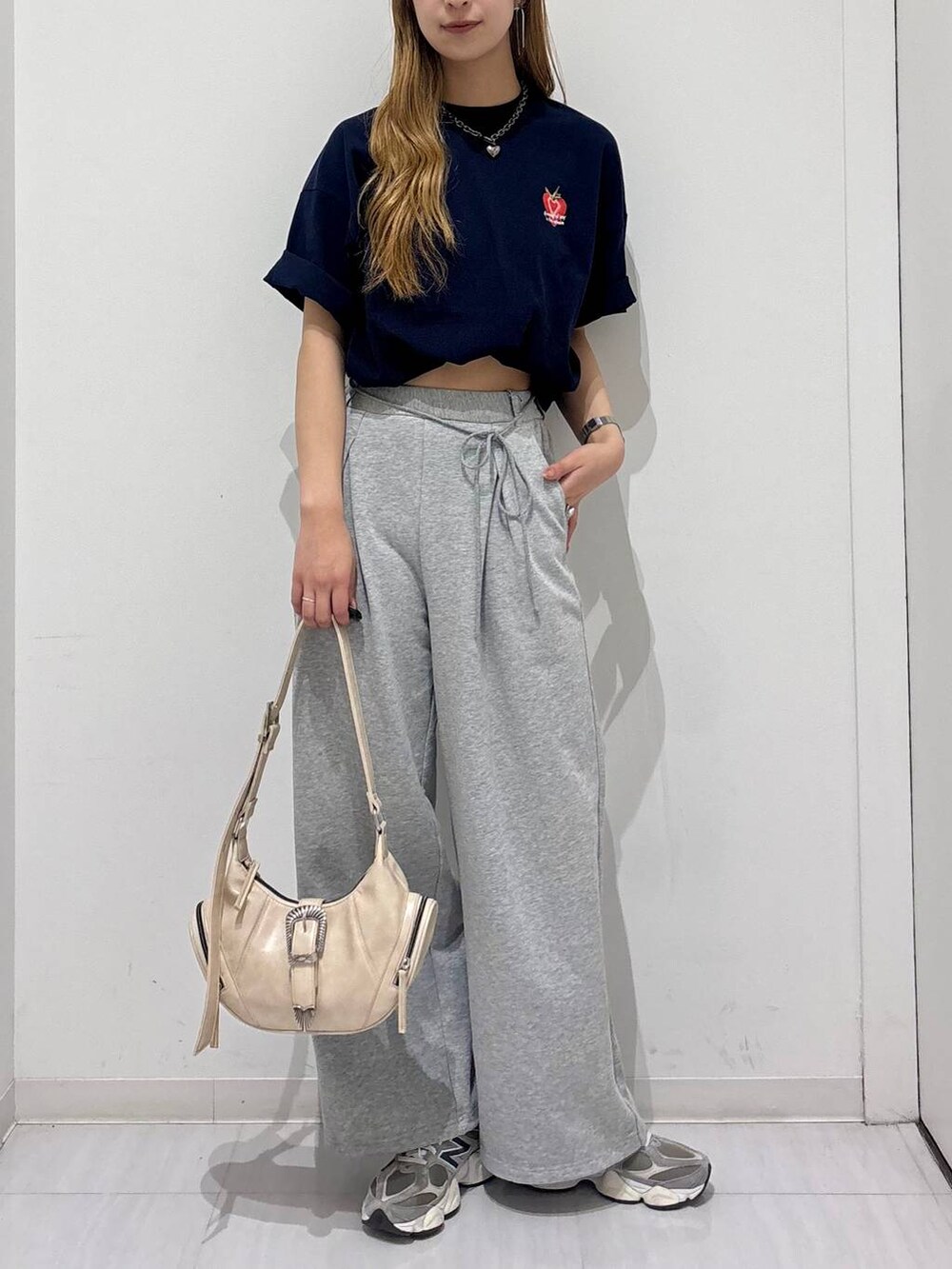 ホワイト系のショルダーバッグ、ブルー系のTシャツ/カットソー、グレー系のスウェットパンツを着用したレディースの春コーディネートの2枚目の写真