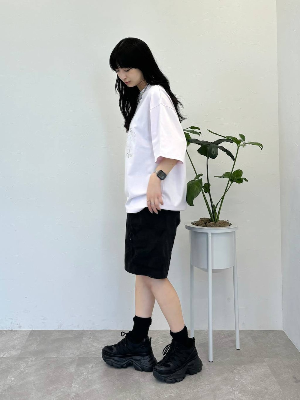 ブラック系のスニーカー、ブラック系のカーゴパンツ、ホワイト系のTシャツ/カットソーを着用したレディースの春コーディネートの3枚目の写真