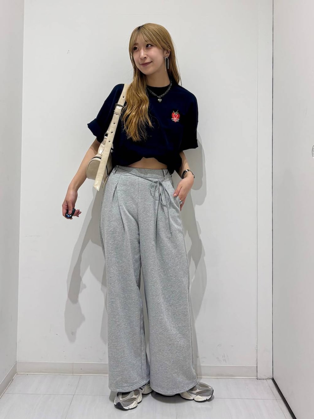 ホワイト系のショルダーバッグ、ブルー系のTシャツ/カットソー、グレー系のスウェットパンツを着用したレディースの春コーディネートの6枚目の写真