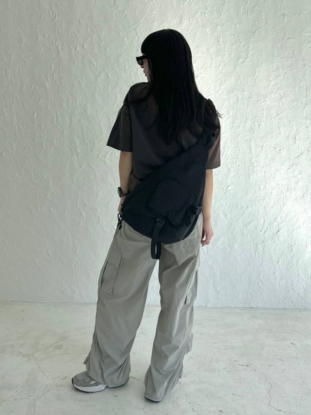 ブラック系のボディバッグ/ウエストポーチ、グレー系のカーゴパンツ、グレー系のTシャツ/カットソーを着用したレディースの春コーディネートの4枚目の写真