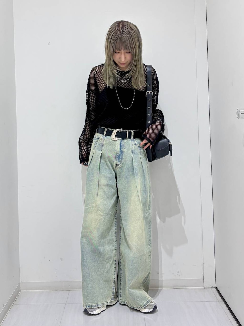 ブルー系のデニムパンツ、ブラック系のTシャツ/カットソー、ブラック系のショルダーバッグを着用したレディースの春コーディネートの2枚目の写真