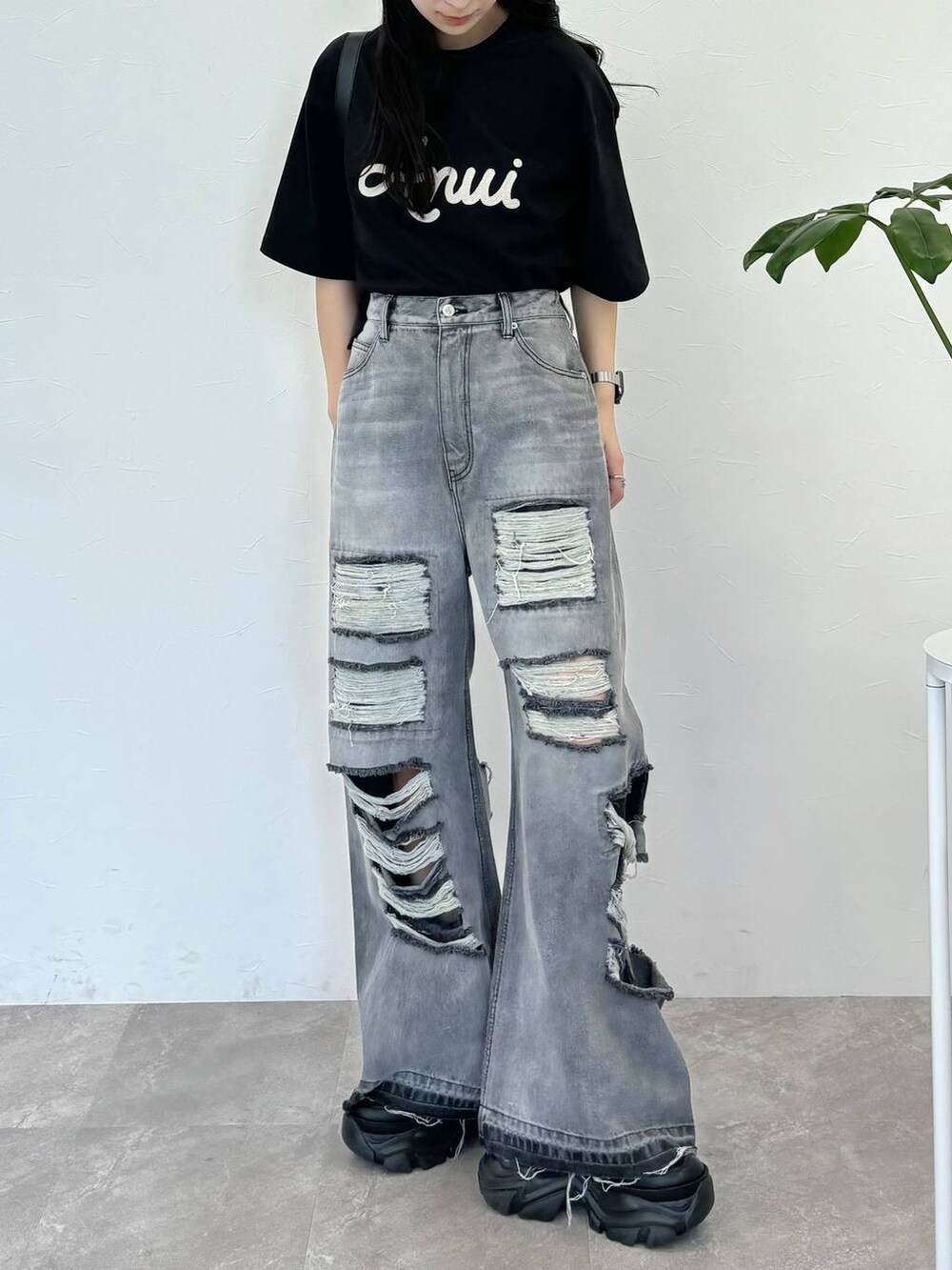 ブラック系のデニムパンツ、ブラック系のスニーカー、ブラック系のTシャツ/カットソーを着用したレディースの春コーディネートの2枚目の写真