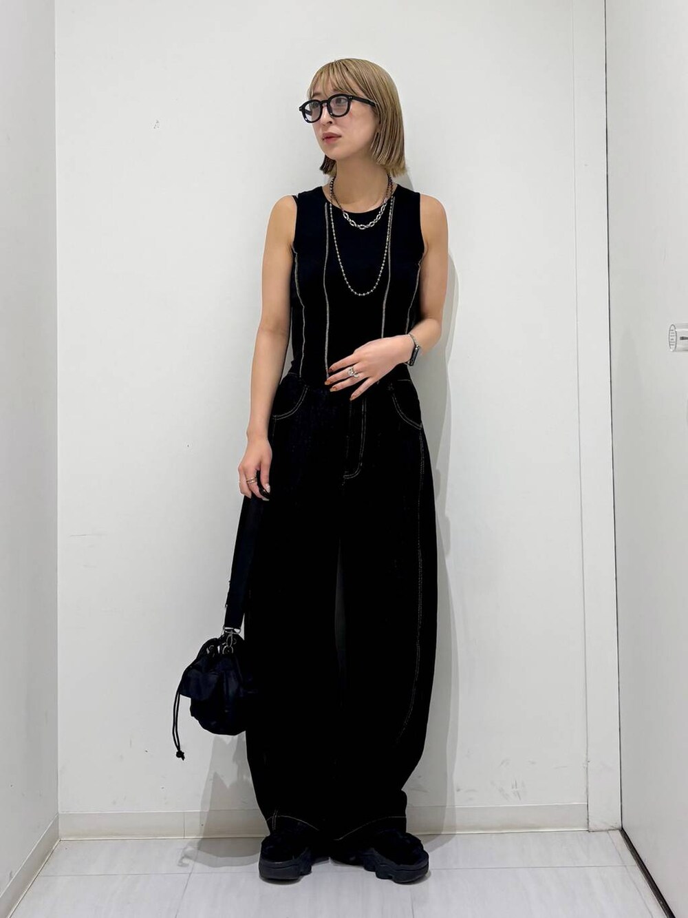 ブラック系のショルダーバッグ、ブラック系のデニムパンツ、ブラック系のタンクトップを着用したレディースの夏コーディネートの7枚目の写真