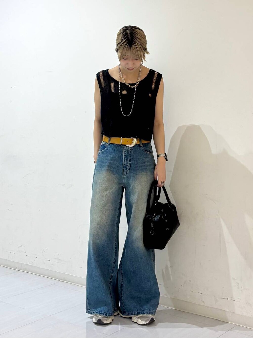ブルー系のデニムパンツ、ブラック系のキャミソール、ブラック系のショルダーバッグを着用したレディースの夏コーディネートの6枚目の写真