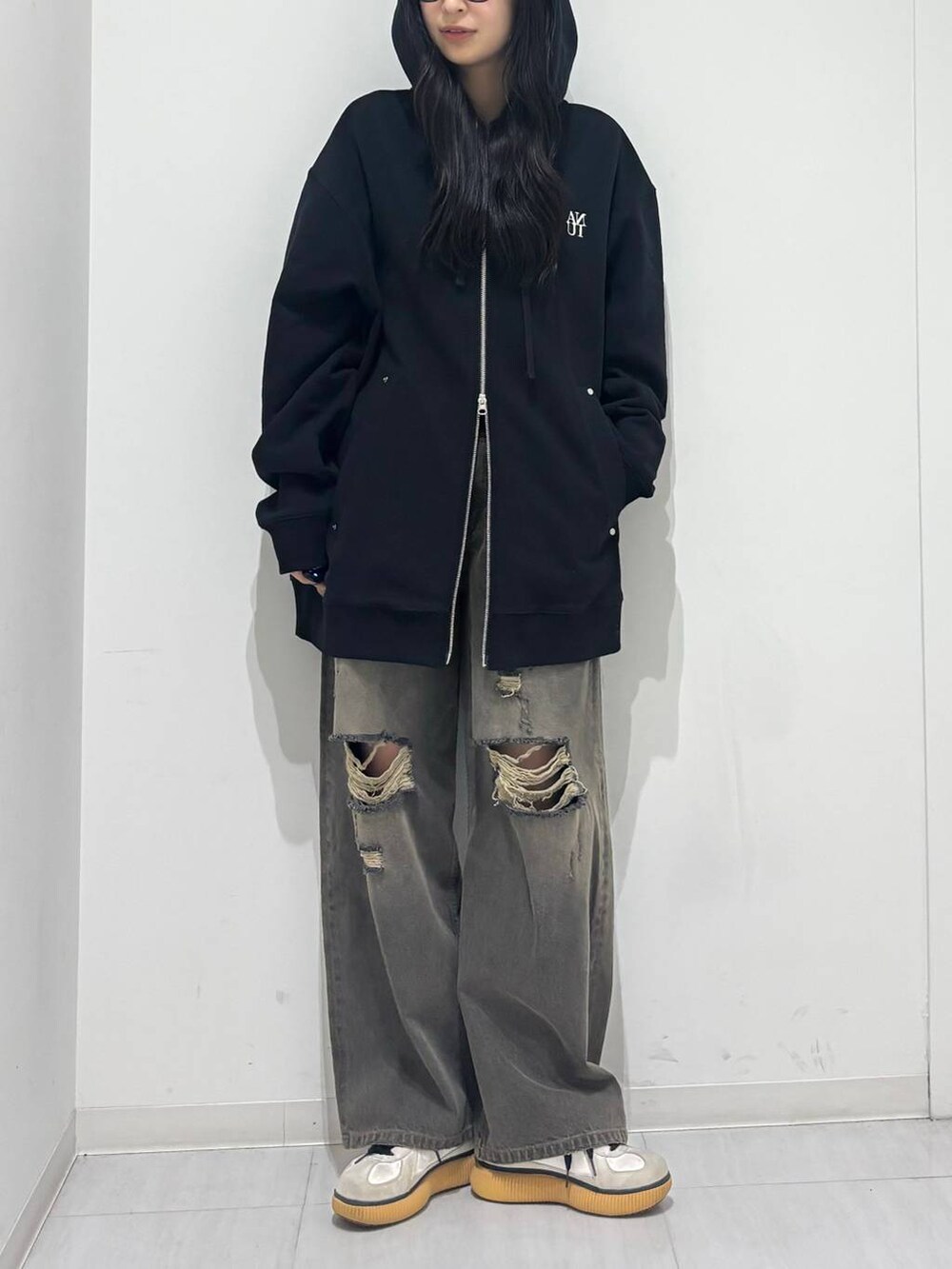 ブラック系のデニムパンツ、ブラック系のパーカーを着用したレディースの秋コーディネートの5枚目の写真