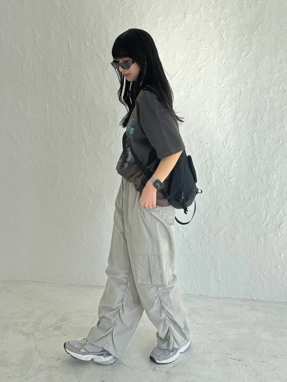 ブラック系のボディバッグ/ウエストポーチ、グレー系のカーゴパンツ、グレー系のTシャツ/カットソーを着用したレディースの春コーディネートの3枚目の写真