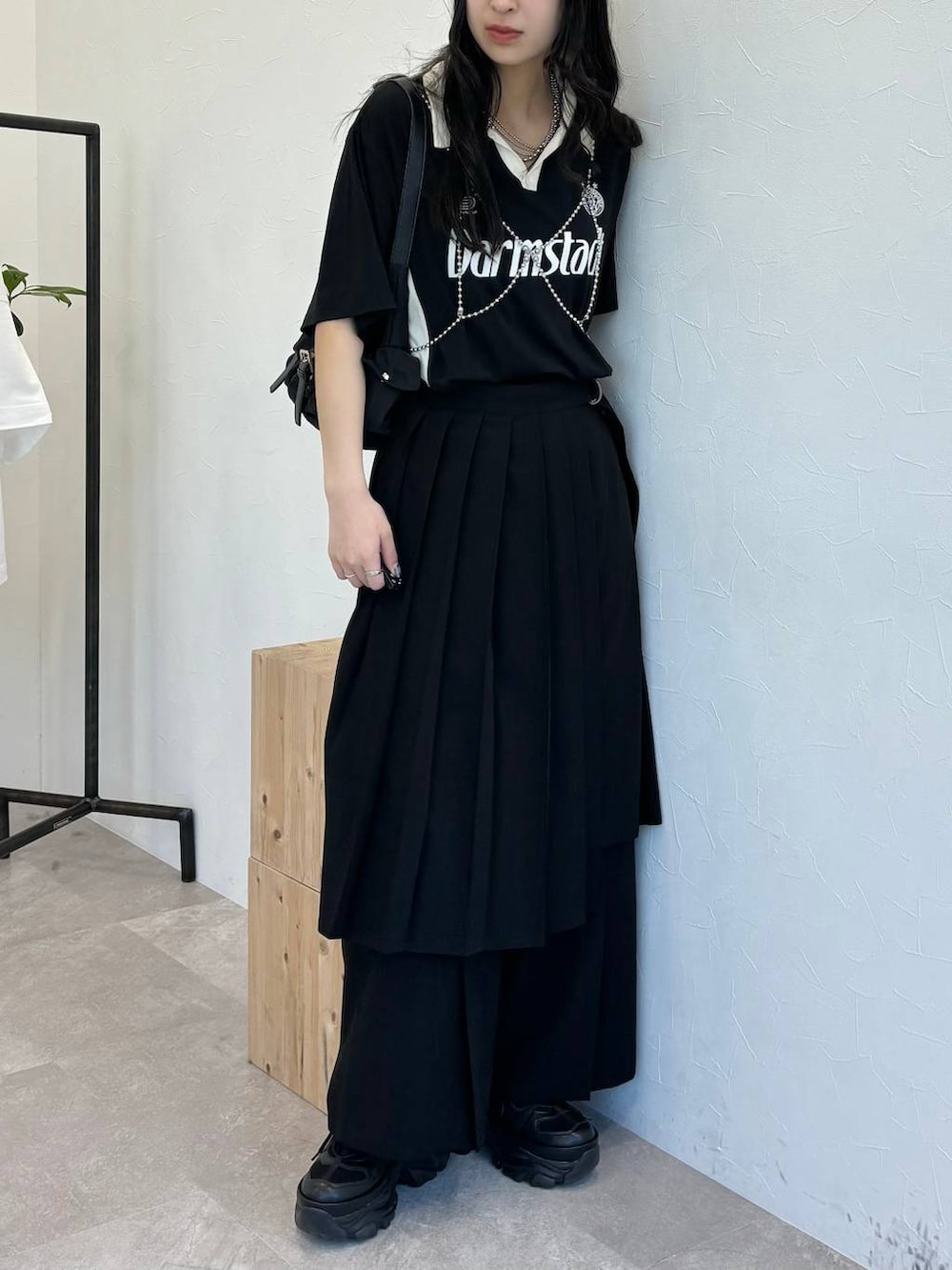 ブラック系のショルダーバッグ、ブラック系のスニーカー、ブラック系のスラックスを着用したレディースの春コーディネートの2枚目の写真