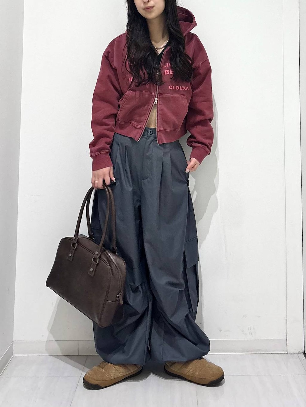 グレー系のカーゴパンツ、ブラウン系のボストンバッグ、レッド系のスウェットを着用したレディースの冬コーディネートの5枚目の写真