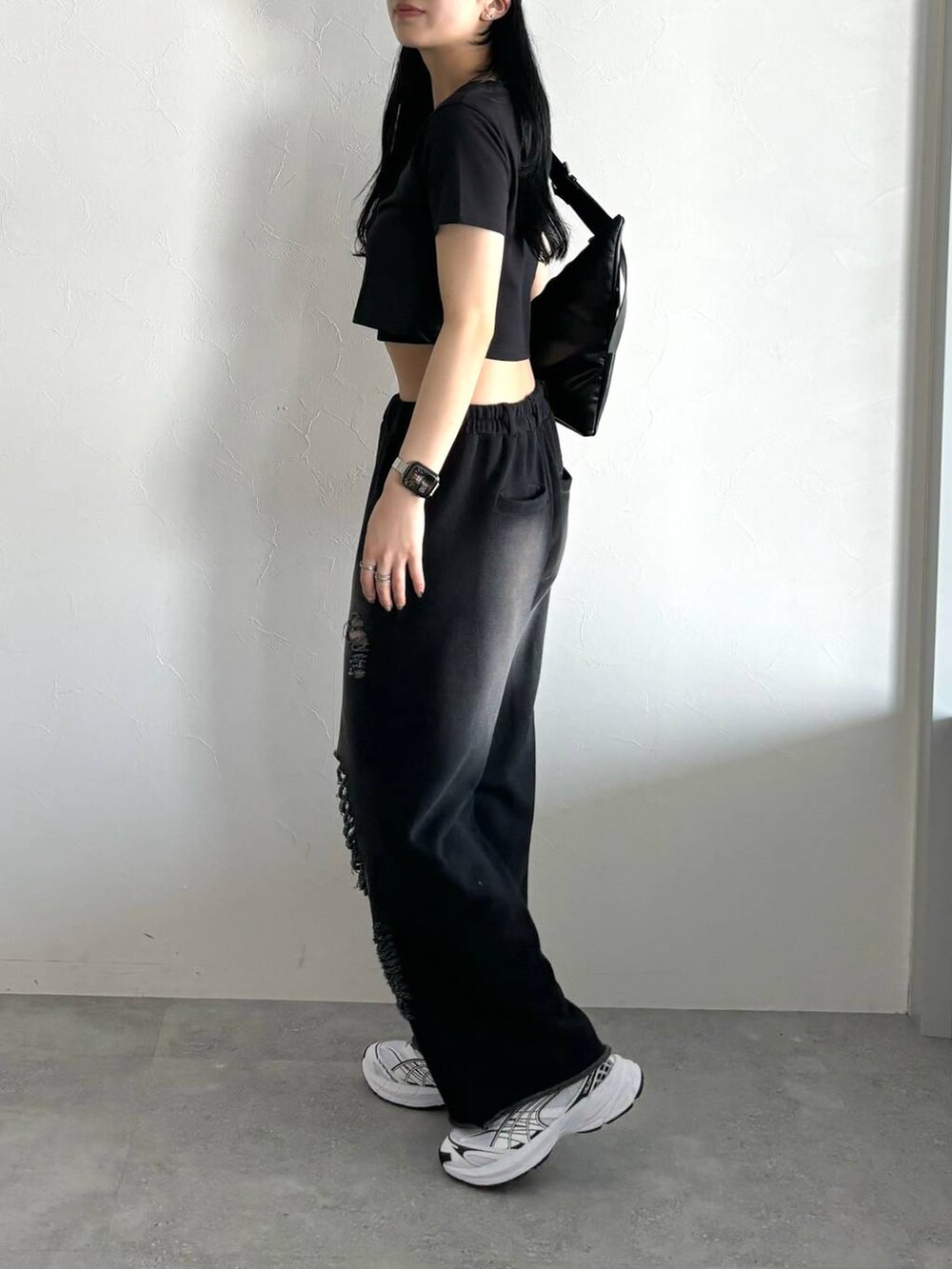 ブラック系のスウェットパンツ、ブラック系のTシャツ/カットソー、ブラック系のショルダーバッグを着用したレディースの春コーディネートの4枚目の写真