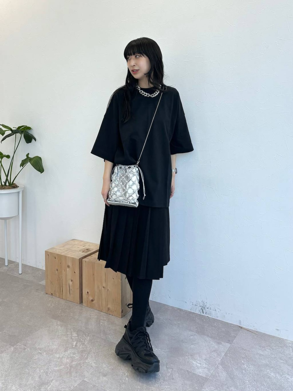ブラック系のスニーカー、シルバー系のショルダーバッグ、ブラック系のスカートを着用したレディースの春コーディネートの2枚目の写真