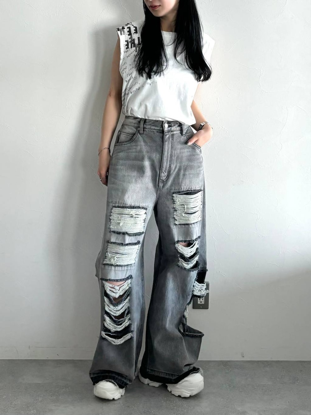 ブラック系のデニムパンツ、ホワイト系のスニーカー、ホワイト系のTシャツ/カットソーを着用したレディースの春コーディネートの2枚目の写真