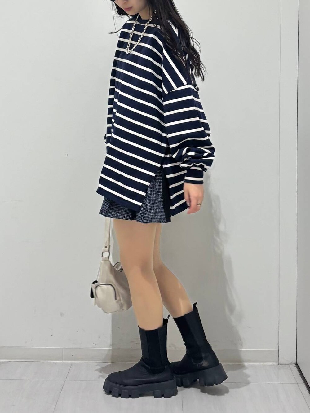 ホワイト系のショルダーバッグ、ブルー系のTシャツ/カットソー、ブラック系のその他パンツを着用したレディースの冬コーディネートの3枚目の写真