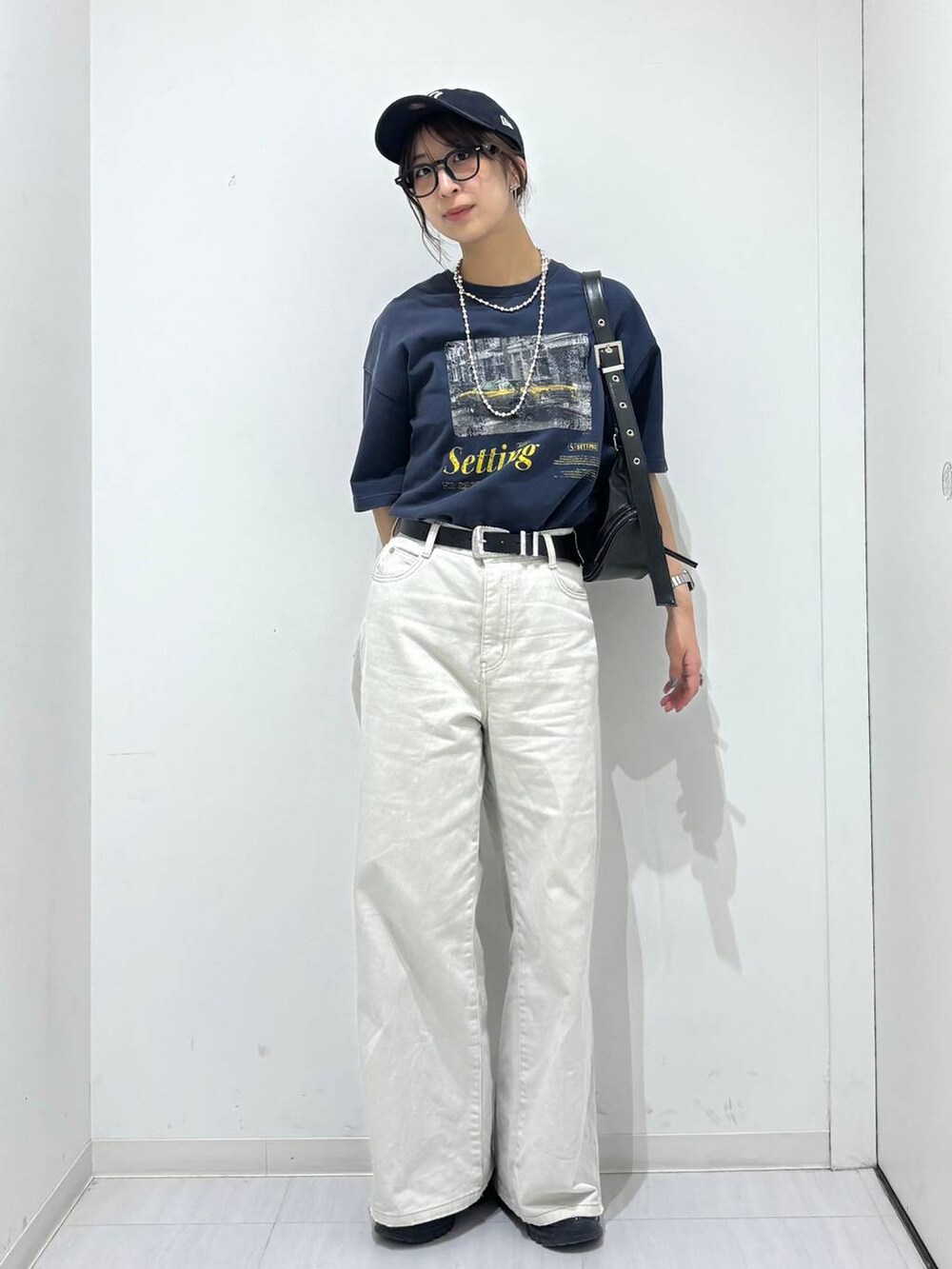 グレー系のデニムパンツ、ブラック系のスニーカー、ブルー系のTシャツ/カットソーを着用したレディースの春コーディネートの2枚目の写真