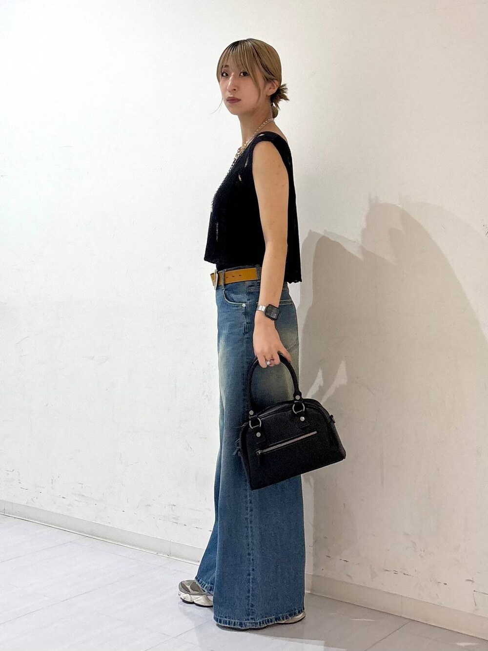 ブルー系のデニムパンツ、ブラック系のキャミソール、ブラック系のショルダーバッグを着用したレディースの夏コーディネートの3枚目の写真