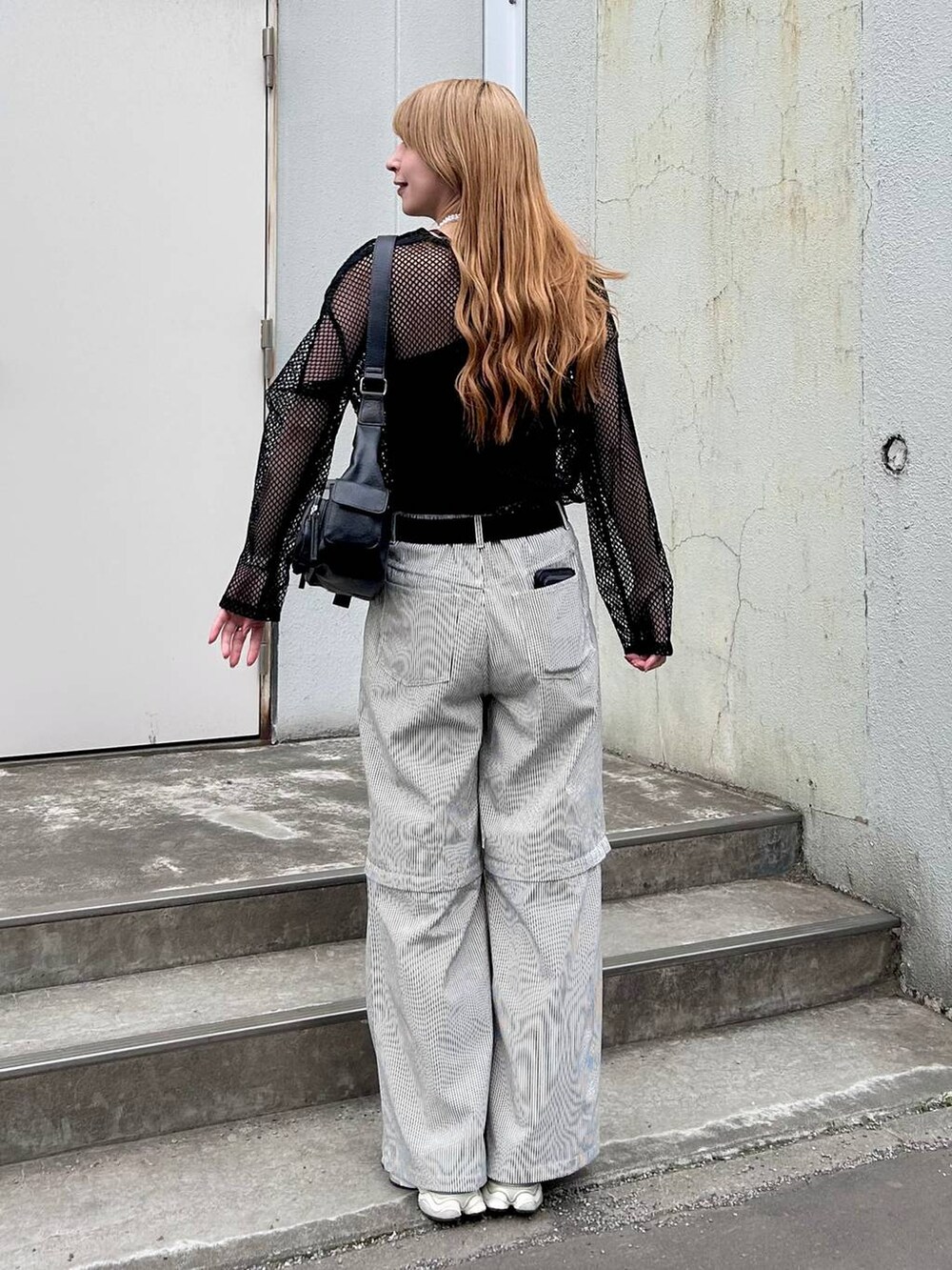 ブラック系のTシャツ/カットソー、ホワイト系のその他パンツ、ブラック系のショルダーバッグを着用したレディースの春コーディネートの5枚目の写真