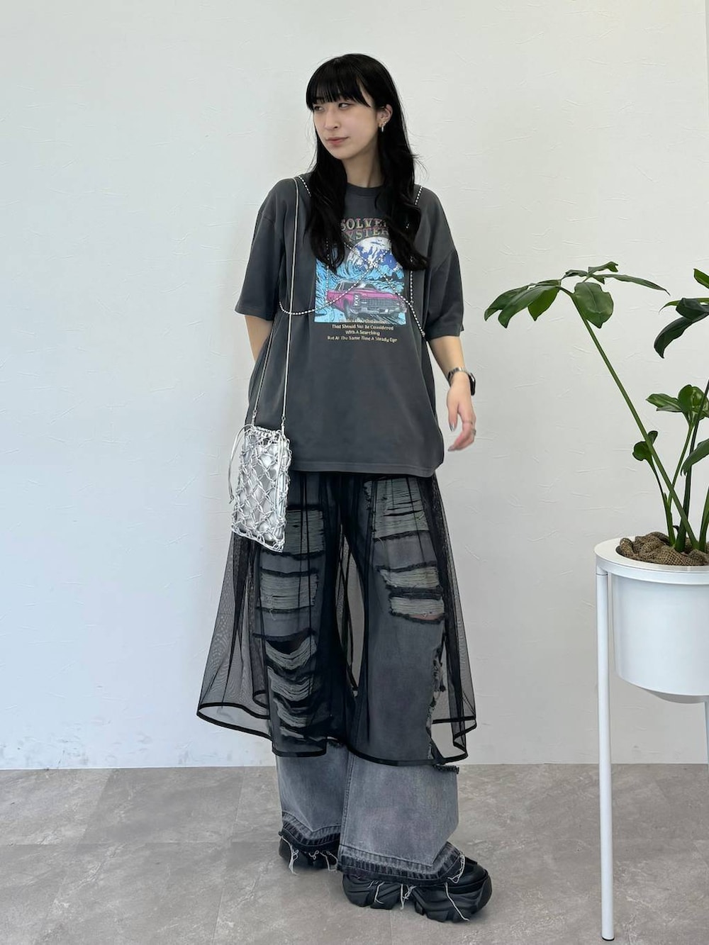 ブラック系のデニムパンツ、グレー系のTシャツ/カットソー、シルバー系のショルダーバッグを着用したレディースの春コーディネートの6枚目の写真