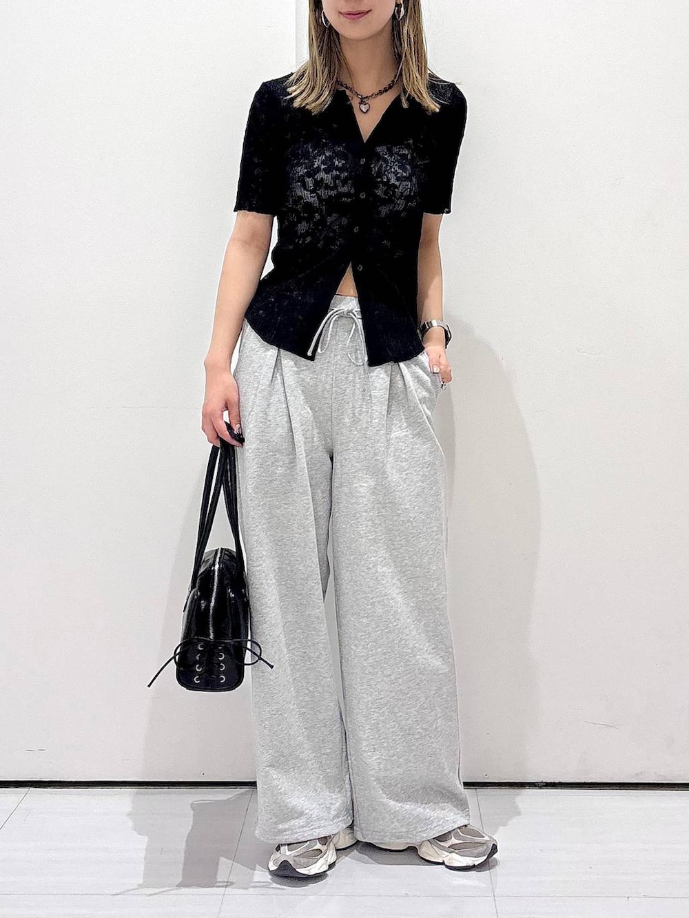 ブラック系のショルダーバッグ、ブラック系のシャツ/ブラウス、グレー系のスウェットパンツを着用したレディースの春コーディネートの3枚目の写真