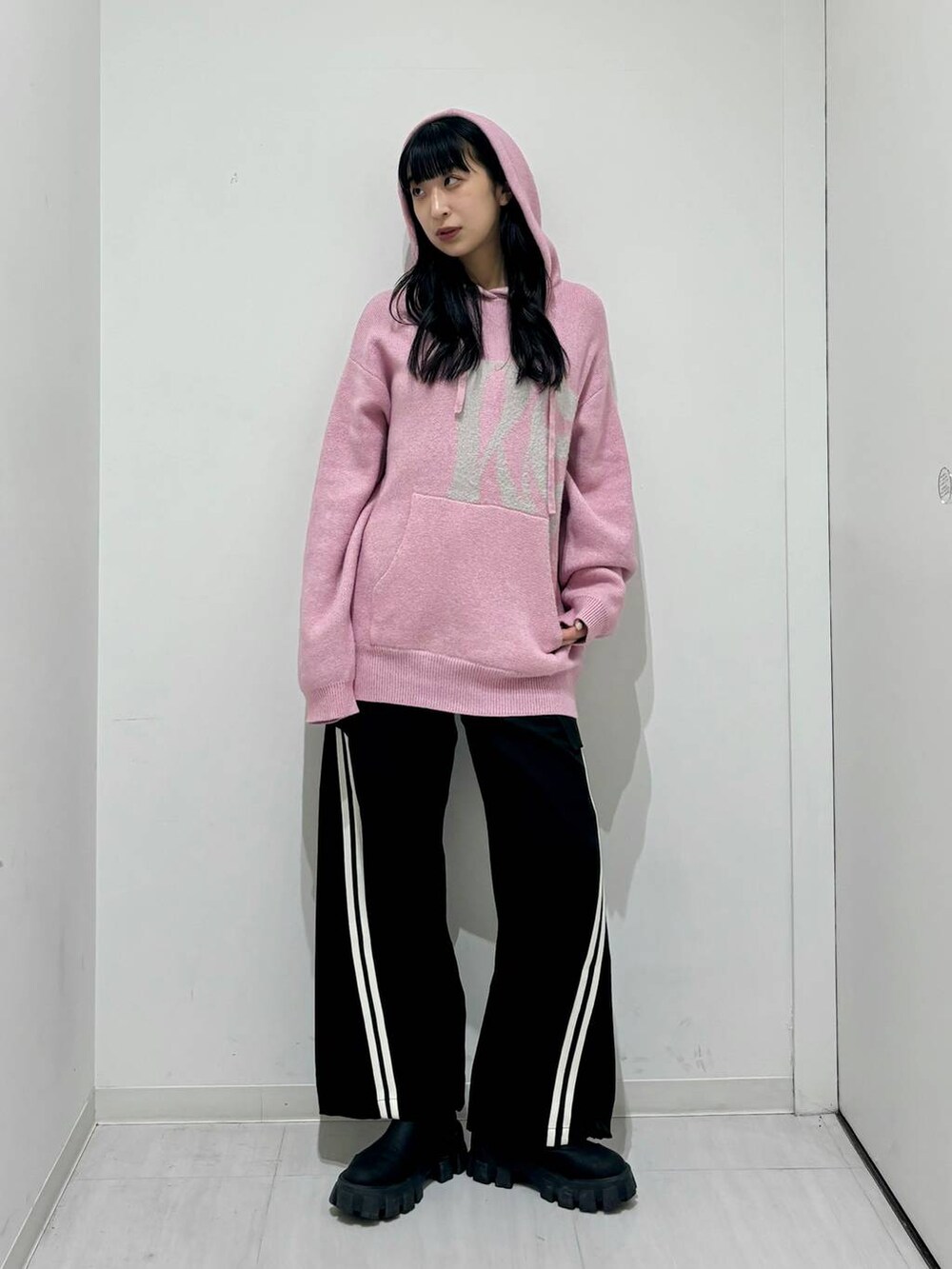 ブラック系のその他パンツ、ブラック系のブーツ、ピンク系のニット/セーターを着用したレディースの冬コーディネートの2枚目の写真