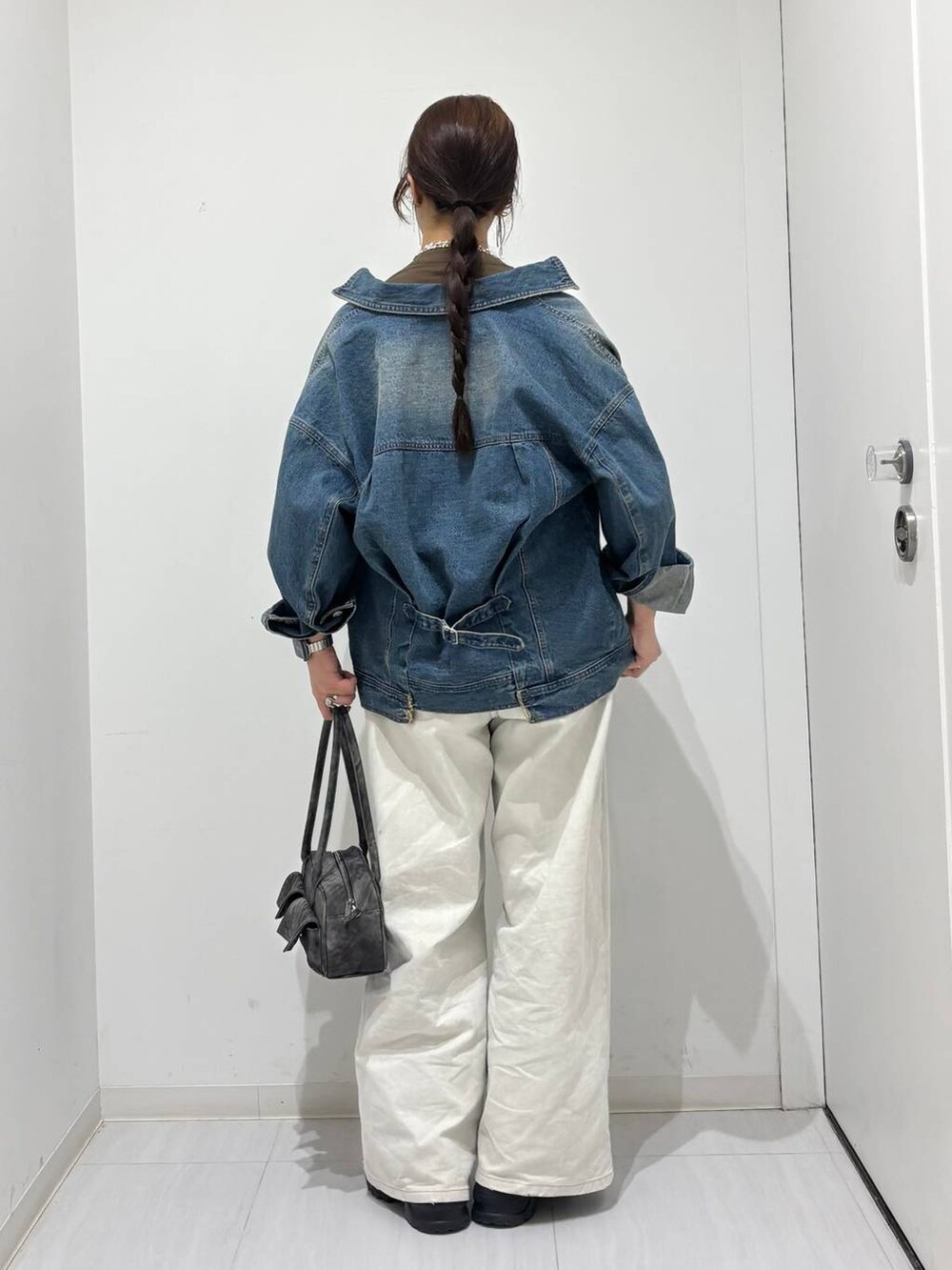 グレー系のデニムパンツ、ブラック系のスニーカー、ブルー系のデニムジャケットを着用したレディースの春コーディネートの5枚目の写真